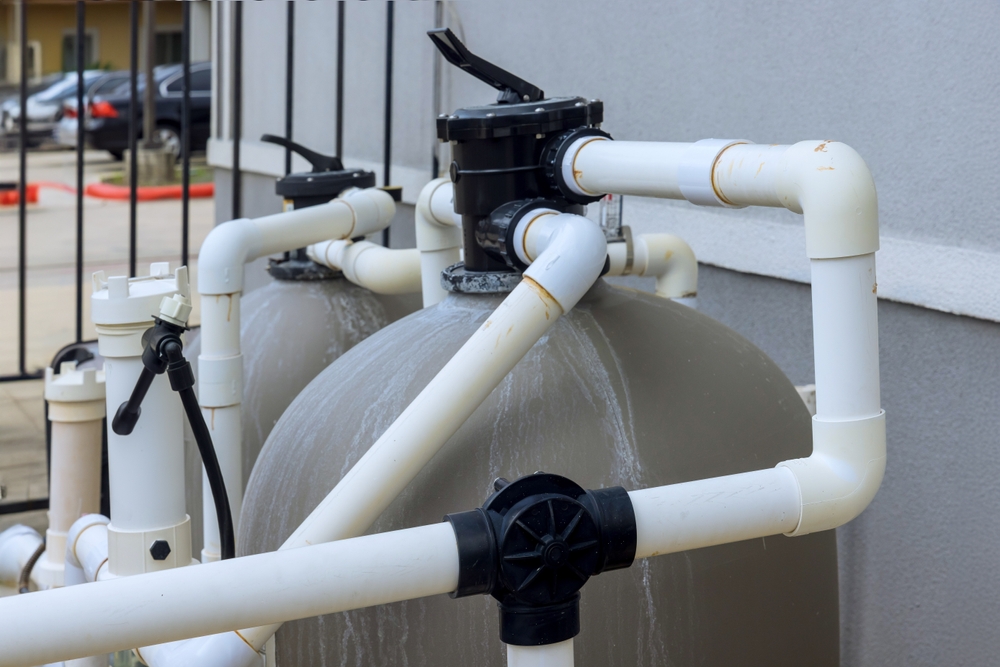 Pool filtration system with connected pipes, emphasizing equipment maintenance for multi-family property management and ensuring water quality.