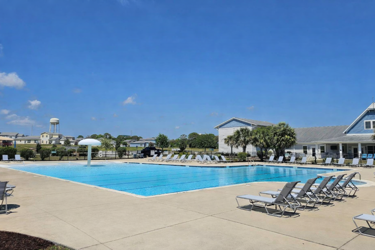 Swimming pool at Eglin Air Force Base, Florida, featuring lounge chairs, water feature, and surrounding greenery, highlighting Specialty Aquatics and Consulting's pool maintenance services.
